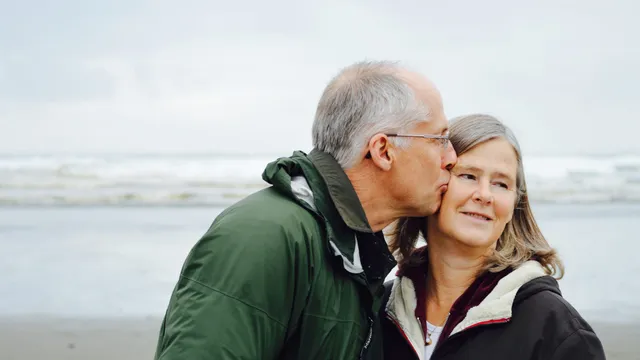 An older couple walking together at the beach